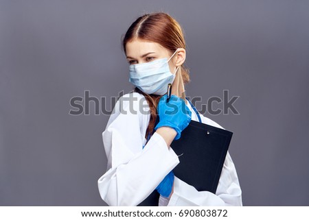Doctor in a medical mask on a gray background                               
