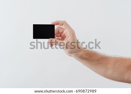 man's hand holds a black paper for inscription
