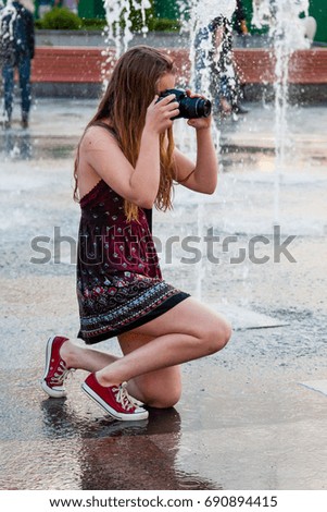 Beautiful girl takes pictures in a fountain close up