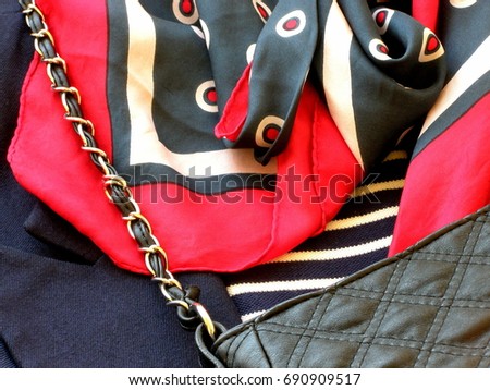 Marine Fashion style. Outfit woman. Neck scarf and red beads on a background of striped knitwear and a pea coat of blue woolen cloth. The concept of the Chanel style. Close-up