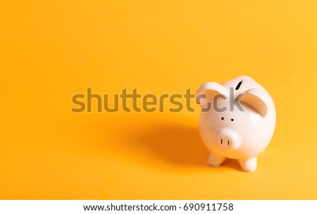 White piggy bank on yellow Royalty-Free Stock Photo #690911758