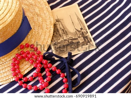Marine Fashion style.  Outfit woman. Straw hat and red beads on a background of striped knitwear. Vintage postcard of 1910 with a seaport of La Rochelle.