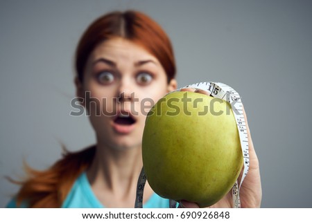 Woman on a diet, measuring tape around her neck, losing weight by summer, fruit                               