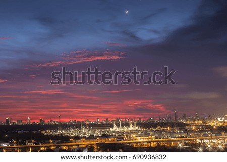 A night landscape view of city and Oil refinery industry under colorful sky at sunset time