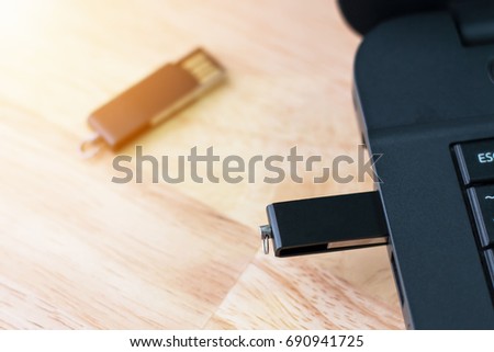 Handy drive or USB flash memory connected to the computer placed on the desk.