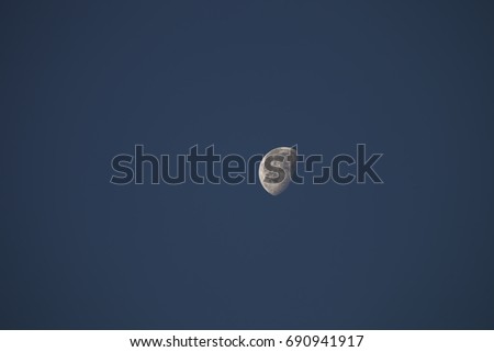 A moon at day time on clear blue sky