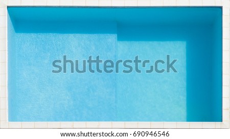 Aerial view in the foreground of a blue pool full of clean water. Around to make marble tiles by the pool edge. In detail, there was a small private pool. Royalty-Free Stock Photo #690946546