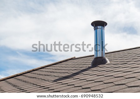 Chimney pipe from stainless steel on the roof of the house Royalty-Free Stock Photo #690948532