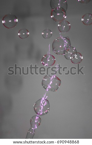 An artistically manipulated photograph of luminescent bubbles in motion.