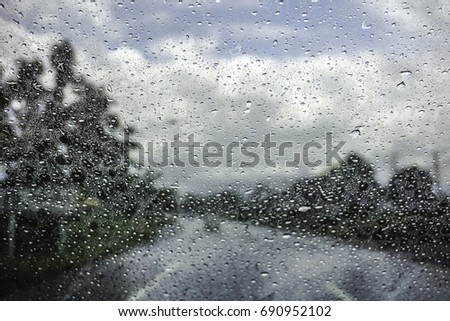 rain drop on the car glass in the rainy day the outside car are the road