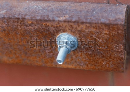New bolt fastening in rusty metal profile