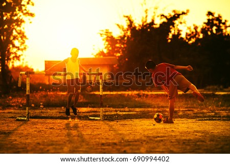 An action and motion picture of a ball and foot of a kid who is playing football in the sunshine day for exercise.