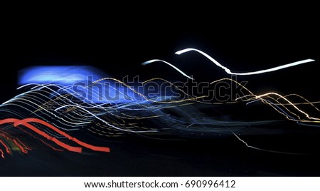 Art images. Abstract effect. The wild light from the car lights and street lights enters the camera lens along the highway at night. Long exposure shutter.
