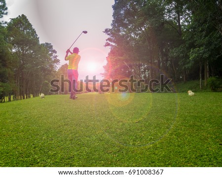 golfer hitting golf ball on beautiful fairway in golf course on sunset