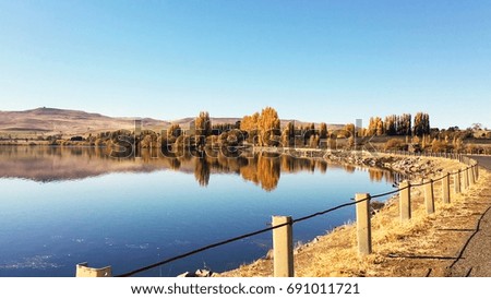 The beautiful country side view of forest trees and mountain reflect on Water mirror, specular reflection with blue sky in autumn season