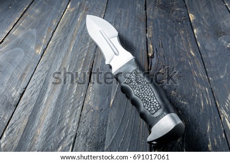 Military knife with black handle of leather. Blacl background.