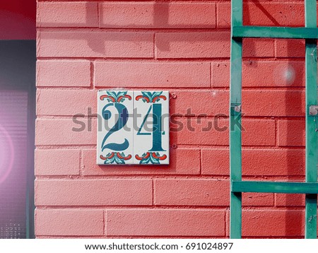 number 24 House number on the wall twenty four (24)