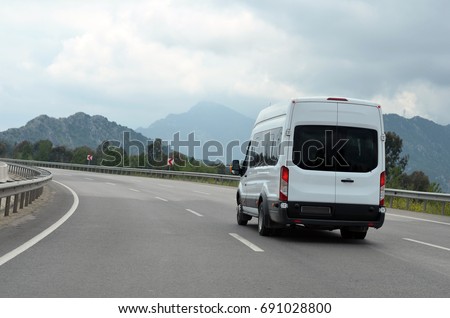 minibus or minicoach on mountain highway Royalty-Free Stock Photo #691028800