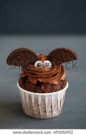 Chocolate muffins, with a chocolate cream in the form of bat on Halloween.