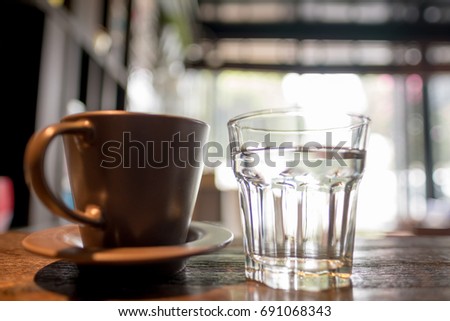 Cup of coffee on old wooden desk. Simple workspace or coffee break in holiday (selective focus).