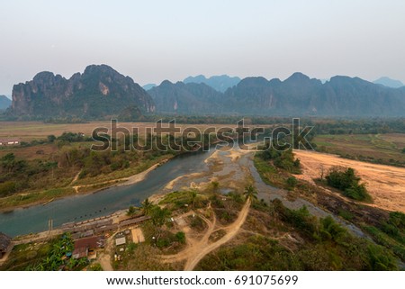 Panorama picture of Nam Song River with tropical vegetation in Vang Vieng from the top, inside the balloon in Laos, during sunrise time.