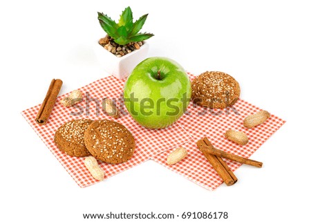 Apple, peanuts, oatmeal cookies and aloe flower
on a white table