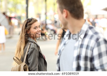 Strangers girl and guy flirting looking each other on the street Royalty-Free Stock Photo #691089019