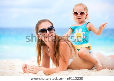 Young mother and her adorable little daughter on beach vacation