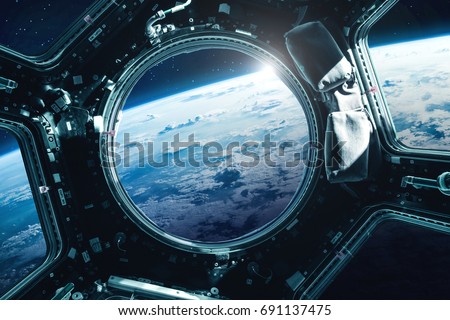 Porthole of space station near the Earth on the background. Elements of this image furnished by NASA Royalty-Free Stock Photo #691137475