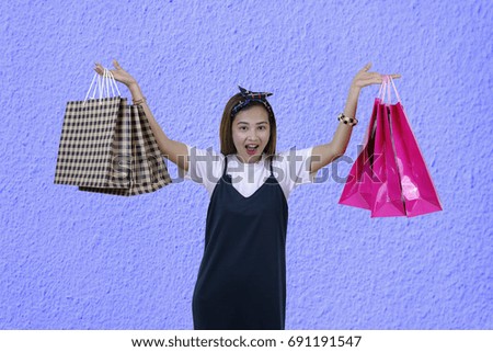 happy woman wearing  with shopping bags on a blue background