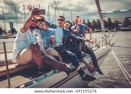 Happy friends taking selfie on a yacht