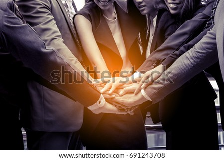 Blurred photo of Image of businesspeople prepare to show team power by putting hands on top of each other as symbol of their partnership