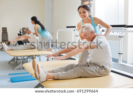 Positive delighted retirement doing stretching exercises