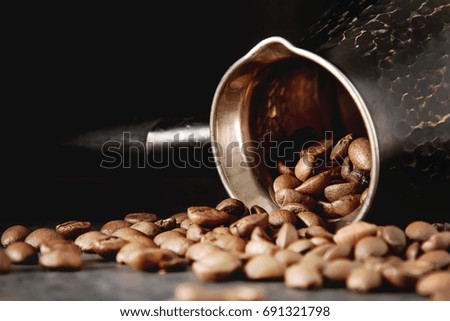 Italian coffee grains in turk. Delicious aromatic drink. Dark background