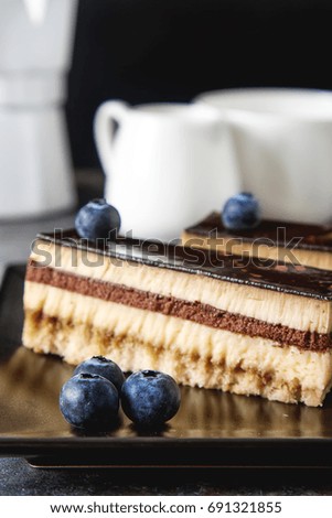 Delicious chocolate cake with blueberries and coffee. Dark background