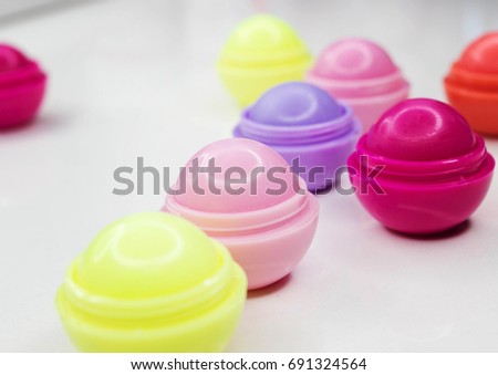Multicolored balsams for lips on a white background of different taste