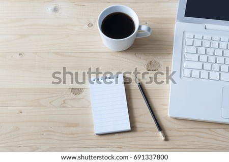 Notebook,pencil,laptop and coffee on wooden table. Royalty-Free Stock Photo #691337800