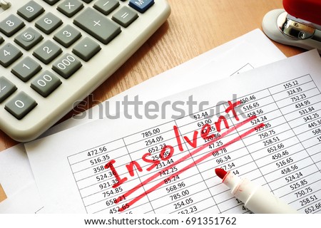 Insolvent written on a paper with financial figures. Royalty-Free Stock Photo #691351762