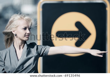 Young woman pointing a direction.