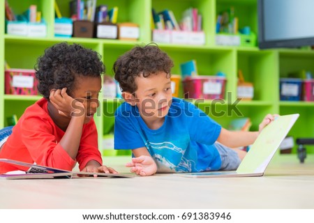 Two boy kid lay down on floor and reading tale book  in preschool library,Kindergarten school education concept Royalty-Free Stock Photo #691383946
