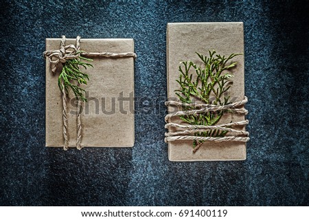Handmade present boxes with thuya branch on black background cel