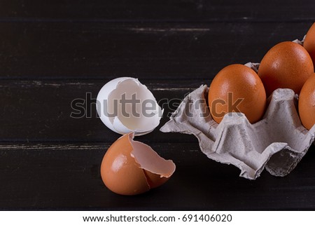 Cardboard egg box And eggshell shells on black wooden background. Eggs container