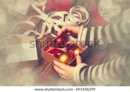 Female hands are wrapping a christmas gift on wooden background