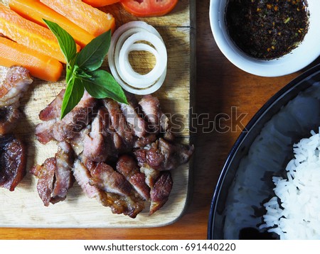 Top view picture of Thai menu set consist of grilled pork, rice and E-san (Northeastern of Thailand)  spicy dressing.