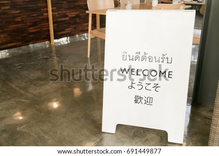 welcome sign on cafe with thai english japanese and chinese lang