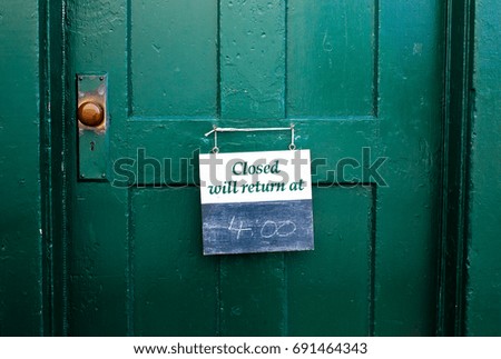 Closed sign hanging on a wooden door