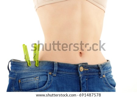 Slim Young Woman who Has Lost Weight Wears her Old Blue Jeans White Background.
