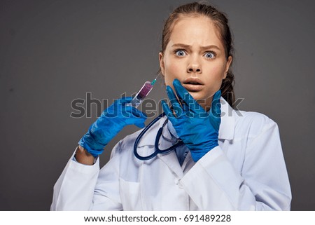 Doctor young woman on a dark background, syringe, vaccine                            