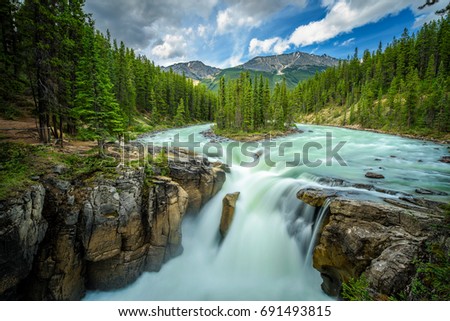 Upper Sunwapta Falls in Jasper National Park, Canada. The water originates from the Athabasca Glacier. Long exposure. Royalty-Free Stock Photo #691493815