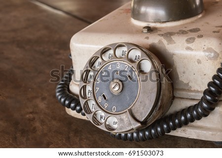 Vintage - Old Beige phone retro on a wood table - 80's concept image